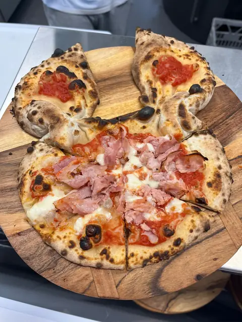 Pizza cut into slices on a wooden board