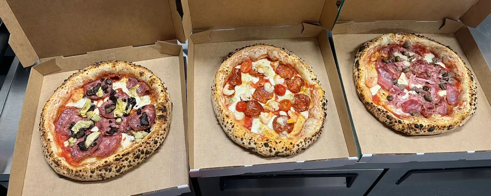 Three Suriano’s pizzas in take-away boxes